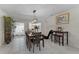 Open dining room featuring tiled floors, view of the kitchen, modern lighting, and a stylish accent chair at 950 Sylvia Dr, Deltona, FL 32725