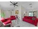 Bright living room featuring tile floors, modern ceiling fan, and comfortable red sofa at 950 Sylvia Dr, Deltona, FL 32725