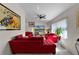 Bright living room with comfortable red sofas, tiled floors, a ceiling fan, and stylish wall art at 950 Sylvia Dr, Deltona, FL 32725