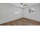 Bedroom showcasing wood-look flooring, white walls, a modern ceiling fan, and natural light from two windows at 1026 Woodall Dr, Altamonte Springs, FL 32714