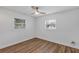 Bedroom showcasing wood-look flooring, white walls, a modern ceiling fan, and natural light from two windows at 1026 Woodall Dr, Altamonte Springs, FL 32714