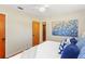 Cozy bedroom featuring hardwood floors, a ceiling fan, and colorful artwork, complemented by blue patterned pillows at 1037 N Virginia Ave, Winter Park, FL 32789