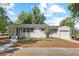 Charming single-story home with a white exterior, gray shutters, and a well-maintained front yard at 1037 N Virginia Ave, Winter Park, FL 32789