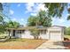 Lovely single-story house with a white exterior, attached garage, and green grass at 1037 N Virginia Ave, Winter Park, FL 32789