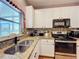 Galley kitchen with stainless steel sink, granite counters and subway tile backsplash at 14143 Ancilla Blvd, Windermere, FL 34786