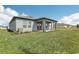 View of the backyard with covered patio, a grassy area and neutral exteriors at 1417 Arbor Hill Dr, Deltona, FL 32725