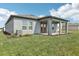 Rear view of home featuring a covered patio, grey exterior, and well-maintained lawn at 1417 Arbor Hill Dr, Deltona, FL 32725