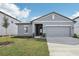 Charming single-story home featuring a gray exterior, manicured lawn, and a two-car garage at 1417 Arbor Hill Dr, Deltona, FL 32725