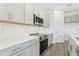 Modern kitchen featuring stainless steel appliances, quartz countertops, and sleek gray cabinetry at 1417 Arbor Hill Dr, Deltona, FL 32725