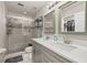 Bright bathroom featuring double sinks, a glass-enclosed shower, and a view into the walk-in closet at 14203 Avenue Of The Grvs, Winter Garden, FL 34787