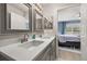 Bright bathroom with double sinks, a framed mirror, and a view to the bedroom at 14203 Avenue Of The Grvs, Winter Garden, FL 34787