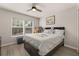 Well-lit bedroom featuring neutral walls, wood floors, a ceiling fan, and a large window at 14203 Avenue Of The Grvs, Winter Garden, FL 34787