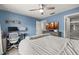 Blue bedroom with a comfy bed, ceiling fan, desk, and view to the ensuite bathroom at 14203 Avenue Of The Grvs, Winter Garden, FL 34787