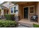 Inviting front porch area with stone supports, a chair, and an address plaque at 14203 Avenue Of The Grvs, Winter Garden, FL 34787