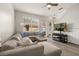 Bright living room featuring a large sectional sofa, wood coffee table, ceiling fan, and modern decor at 14203 Avenue Of The Grvs, Winter Garden, FL 34787