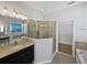 Bathroom featuring granite counters, walk-in shower, separate tub, and a large mirror at 1536 Softshell St, St Cloud, FL 34771