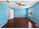 A spacious bedroom with blue walls, ceiling fan, window, and hardwood floor at 1536 Softshell St, St Cloud, FL 34771