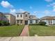 Charming two-story home with stone accents, blue shutters, landscaped yard, and brick walkway at 1536 Softshell St, St Cloud, FL 34771