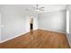 Bright main bedroom featuring hardwood floors, ceiling fan, and ensuite bathroom at 1536 Softshell St, St Cloud, FL 34771