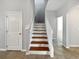 Staircase with wooden steps and white risers, leading to the upper level of the home with natural light at 1536 Softshell St, St Cloud, FL 34771