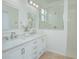 Bright bathroom featuring double vanity, decorative mirrors, and a glass-enclosed shower at 1660 Mountclair Ct, Mount Dora, FL 32757