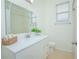 Bathroom featuring a large mirror, white vanity, tiled floors, and shower with natural light at 1660 Mountclair Ct, Mount Dora, FL 32757