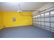 Spacious two car garage with modern garage door and bright yellow back wall at 1660 Mountclair Ct, Mount Dora, FL 32757