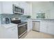 Modern kitchen featuring stainless steel appliances, white countertops, and ample cabinet space at 1660 Mountclair Ct, Mount Dora, FL 32757