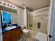 Cozy bathroom featuring a shower-tub combo with glass doors and blue countertops at 229 Silverton Rd, Davenport, FL 33897