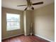 Comfortable bedroom with wood floors, a window, and a ceiling fan at 2446 Temple Grove Ln, Kissimmee, FL 34741