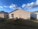 Rear exterior of the home showing a grassy yard, air conditioner, and siding at 2450 Southern Oak St, The Villages, FL 32162