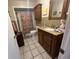 This functional bathroom features tile floors, a shower-tub combo, and a dark wood vanity at 2626 Balkan St, Apopka, FL 32703