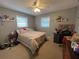 This carpeted bedroom is illuminated by a ceiling fan and plenty of natural light through the two windows at 2626 Balkan St, Apopka, FL 32703