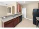 Kitchen with stainless steel double sink, wooden cabinetry, and black appliances at 2840 Grasmere View Pkwy, Kissimmee, FL 34746