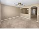 Cozy living room with neutral carpet, a ceiling fan, and an open archway leading to additional living space at 2840 Grasmere View Pkwy, Kissimmee, FL 34746