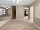 Bright living area featuring carpet, a staircase, and an archway leading to the kitchen at 2840 Grasmere View Pkwy, Kissimmee, FL 34746