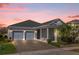 Charming single-story home featuring a two-car garage and well-manicured landscaping, captured at sunset at 2993 Irish Peach Dr, Winter Garden, FL 34787