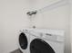 Modern laundry room equipped with a washer and dryer and overhead storage at 2993 Irish Peach Dr, Winter Garden, FL 34787