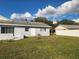 The backyard has an open lawn with a view of the house's exterior and a neighboring fence at 3112 Eleuthera Ln, Orlando, FL 32827