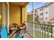 Private balcony featuring chairs, a table, and views of community landscaping at 3338 Robert Trent Jones Dr # 20804, Orlando, FL 32835