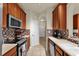 Galley kitchen featuring wooden cabinets, stainless steel appliances, and tiled backsplash at 3338 Robert Trent Jones Dr # 20804, Orlando, FL 32835