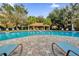 Community pool with lounge chairs, shade structure, and lush landscaping at 3338 Robert Trent Jones Dr # 20804, Orlando, FL 32835