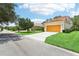 Exterior home with a paved driveway and two-car garage with a well manicured lawn at 3350 Pegaso Ave, New Smyrna Beach, FL 32168