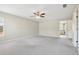 Spacious main bedroom with soft carpet, ceiling fan, and access to the main bathroom at 3350 Pegaso Ave, New Smyrna Beach, FL 32168