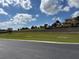 A glimpse of a perfectly manicured lawn with luxurious homes built in the distance on the horizon at 336 Caladium Ave, Lake Alfred, FL 33850