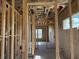 Hallway showcasing the initial stages of construction with wooden frames, and a view of the window at 336 Caladium Ave, Lake Alfred, FL 33850