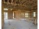 Spacious living room showcasing the initial stages of construction with exposed wooden beams and framing for an open-concept design at 336 Caladium Ave, Lake Alfred, FL 33850