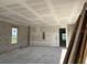 Spacious living room under construction with installed drywall, featuring a window with a view and unfinished floors at 336 Caladium Ave, Lake Alfred, FL 33850