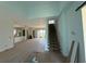 Spacious open-plan living area with hardwood flooring, a grand staircase, and lots of natural light, perfect for modern living at 336 Caladium Ave, Lake Alfred, FL 33850