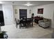 Dining area with a dark wood table, seating for six, piano, and access to a modern kitchen at 3810 Arboreal Ct, Deland, FL 32724